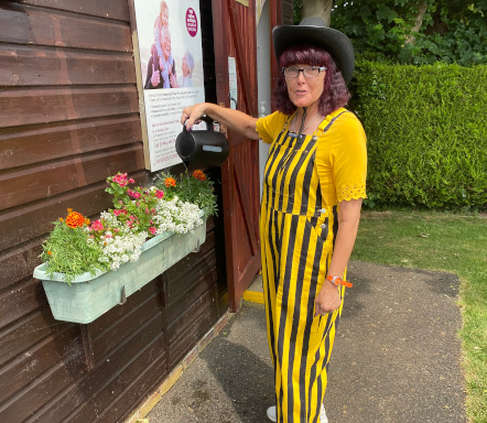 Club member watering flowers in casual dress